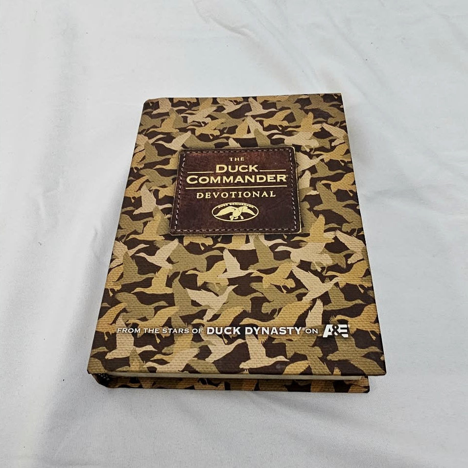 Angled view of The Duck Commander Devotional hardcover showing its cover and thickness.