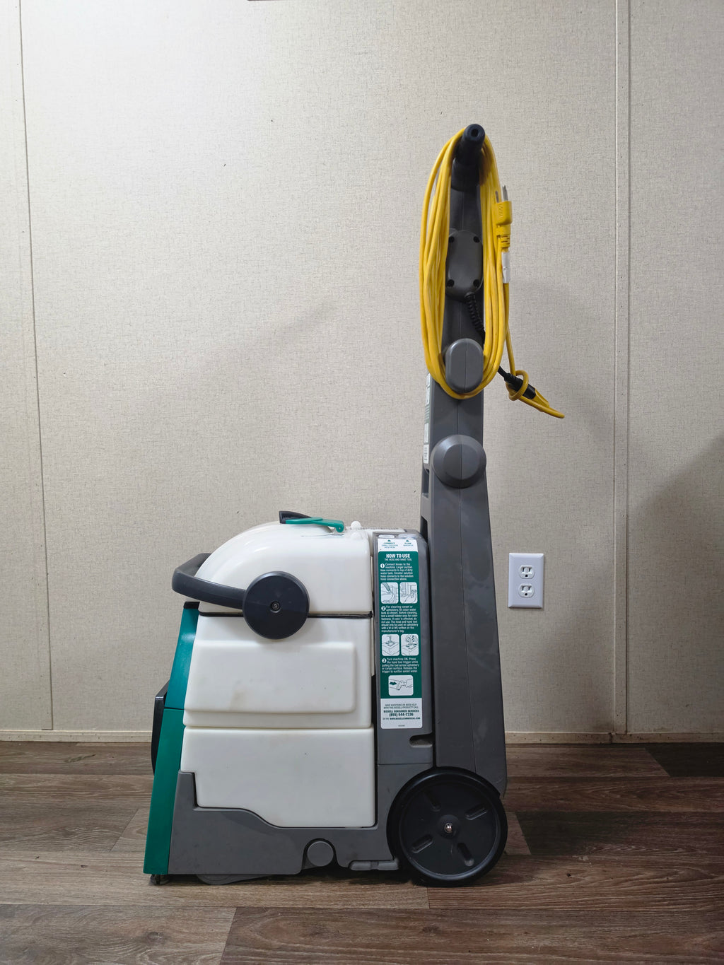 Right side profile of the BISSELL BigGreen cleaner showing the removable tanks and rear wheel.