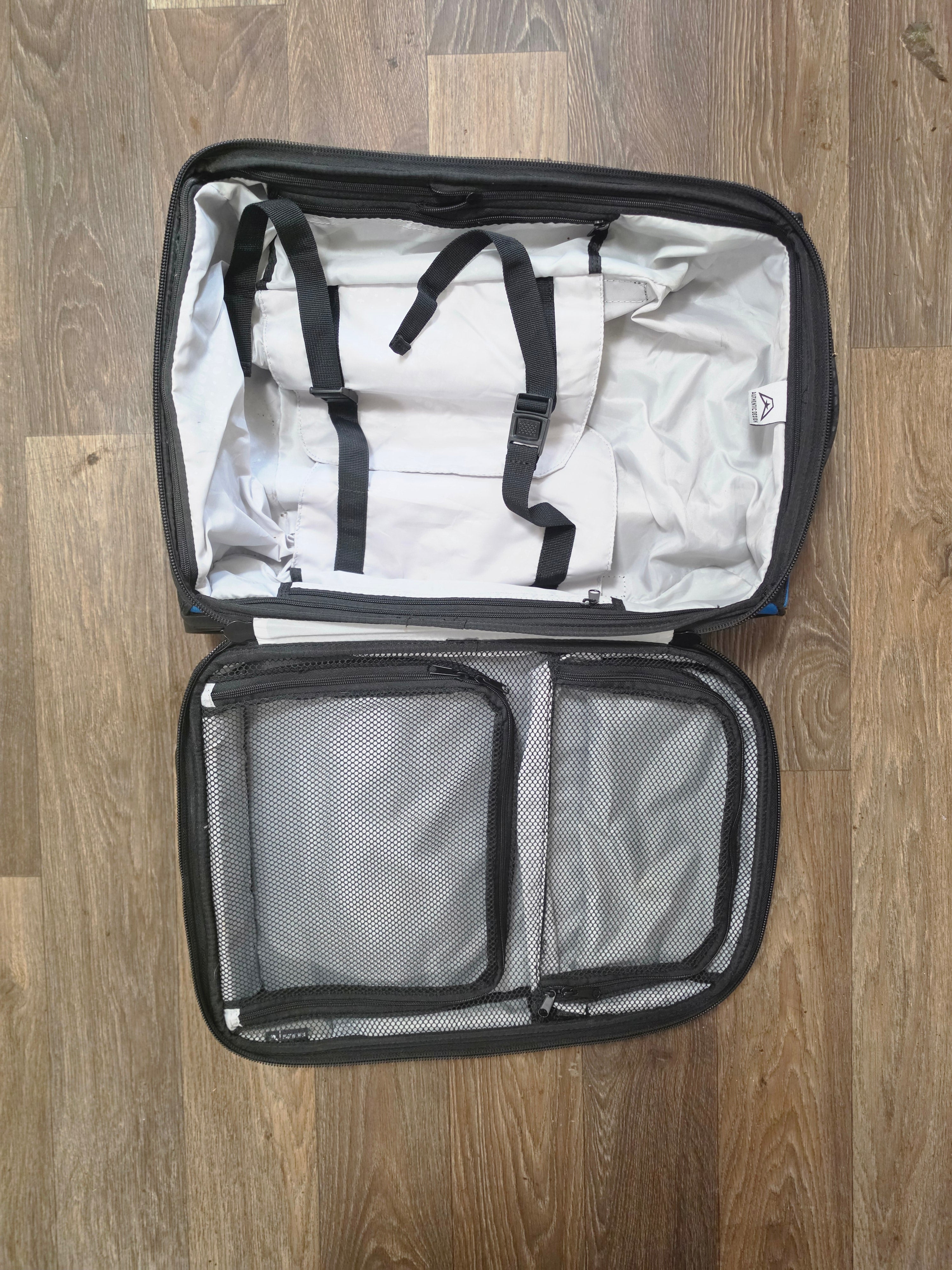 Open American Kargo roller bag showing gray lining, compression straps, and mesh dividers.