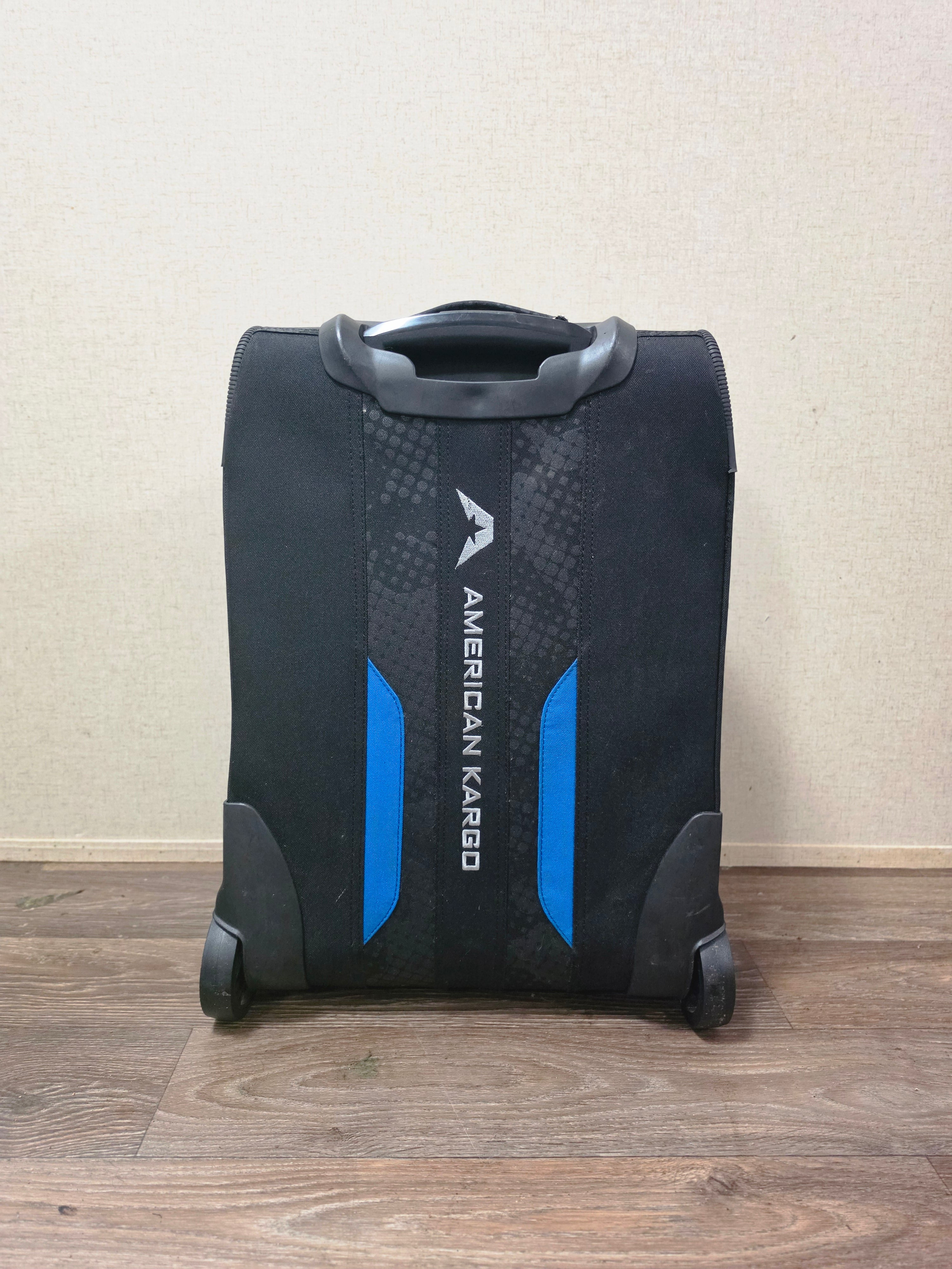 Rear view of the American Kargo roller bag showing the molded back, carry handle, and wheels.