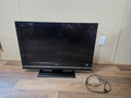 Front view of the black Sony Bravia 32-inch KDL-32XBR9 TV with stand and power cord.