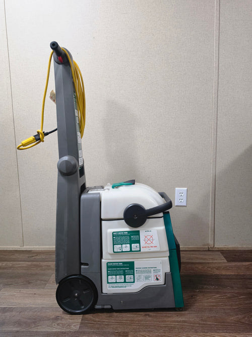 Left side profile of the BISSELL BigGreen carpet cleaner showing wheels, tanks, and instruction labels.