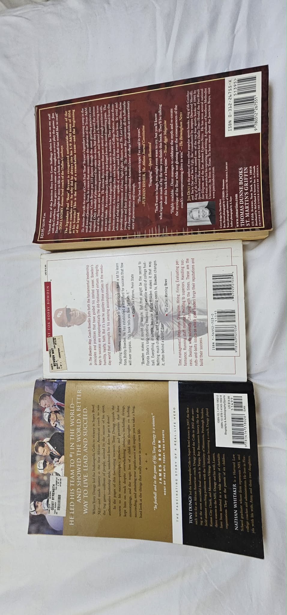 Back covers of four pre-owned football and coaching books arranged in a row.