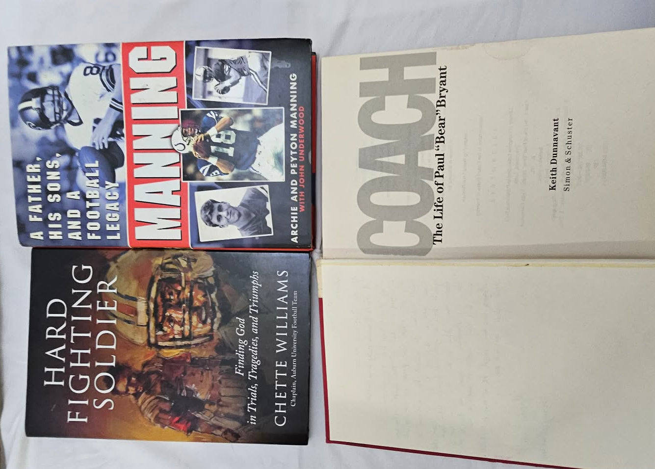 Four football books including Manning, Coach, Hard Fighting Soldier, and Bear Bryant titles.
