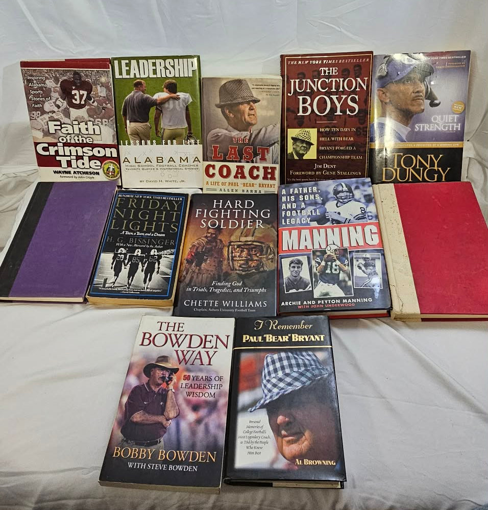 Twelve pre-owned Alabama football, coaching, and sports books arranged together on a white bed.