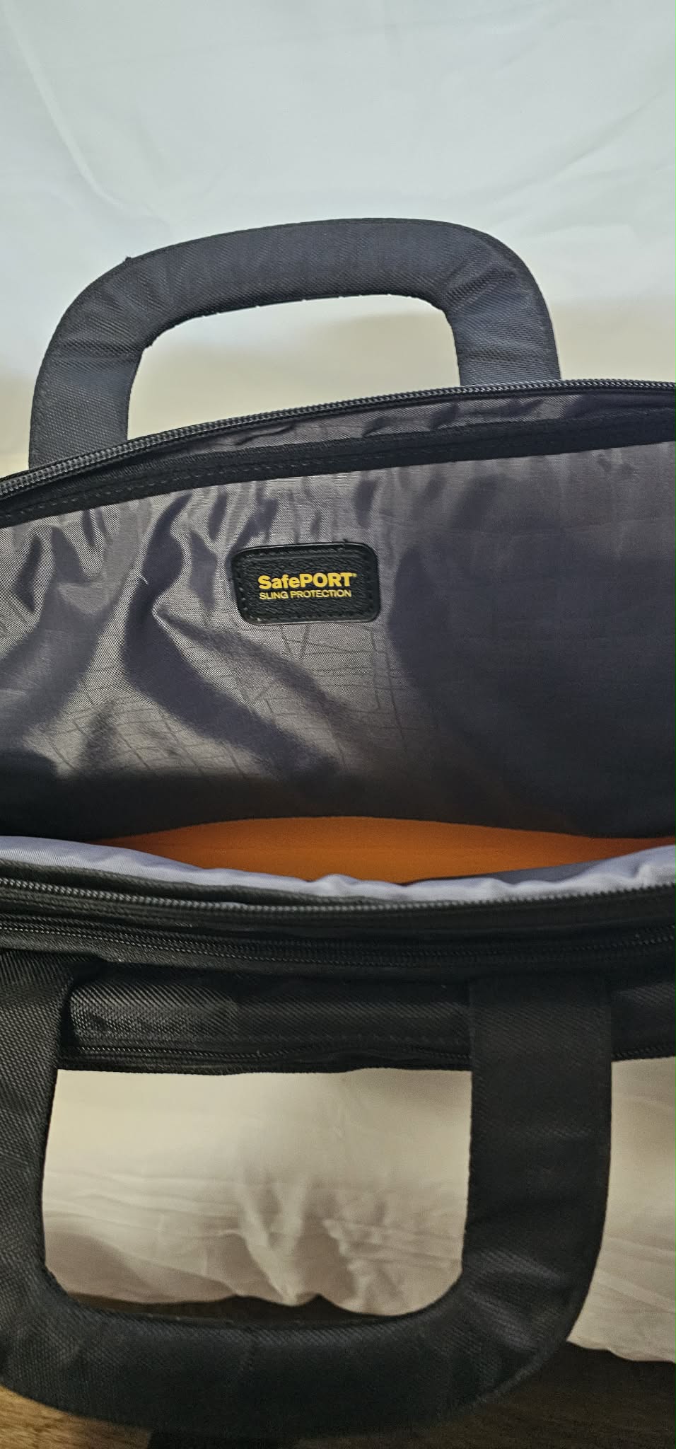 Close-up of the SafePORT label and orange-accented padded laptop compartment.