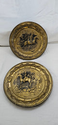 Pair of vintage Made in England brass-tone embossed wall plates featuring equestrian hunting scenes with riders, horses, and hounds.