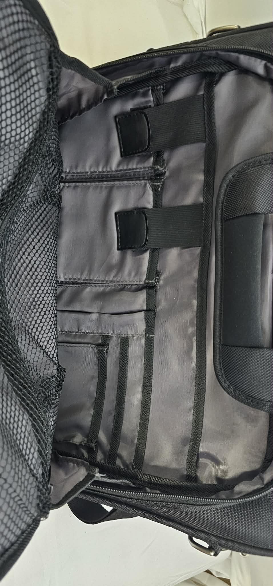 Close-up of the Dell briefcase organizer showing gray lining, accessory loops, pockets, and securing tabs.