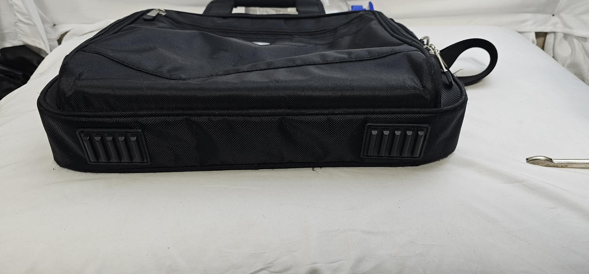 Bottom view of the black Dell laptop briefcase showing the two rectangular rubber feet.