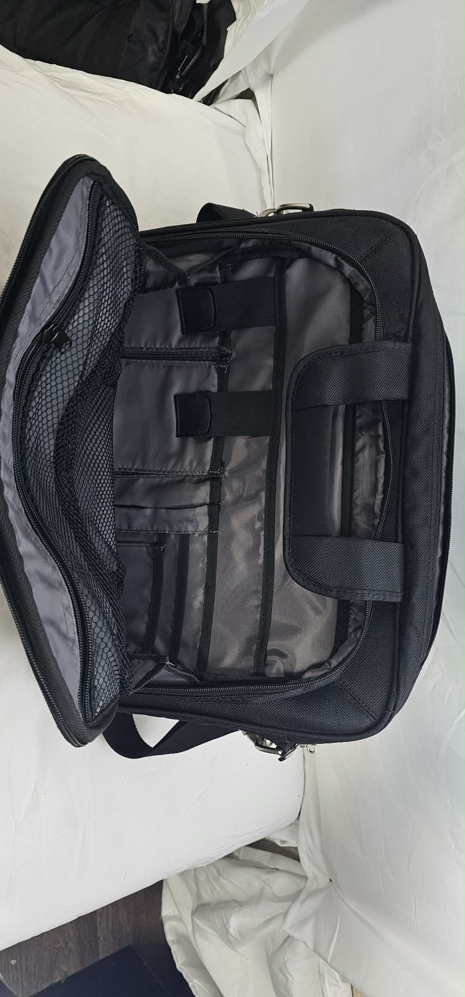 Open Dell laptop briefcase showing the gray organizer interior, mesh pocket, accessory loops, and small storage pockets.